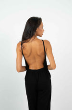 Black jumpsuit with a wide square bare back, which stops at the hips.