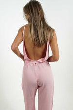 Pink plunge backless jumpsuit with adjustable belt.