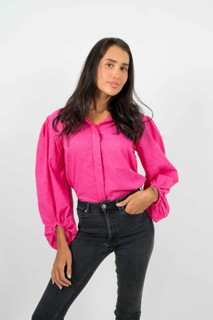 
            
                Load image into Gallery viewer, Open back pink shirt, with slightly puffed long sleeves. Straight cut. Made of cotton with a textured fabric.
            
        