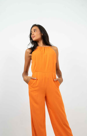 Orange backless jumpsuit. With two front pockets. Gathered at the back.