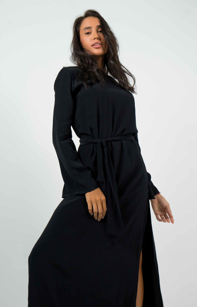 Long black backless dress. Split on the left side. With long sleeves. Can be belted with a knot.