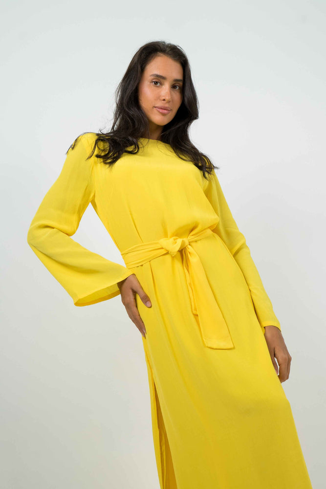 Yellow backless dress, belted with a knot.