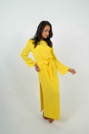 Long yellow bare back dress, slit on the left side. Can be belted at the waist.