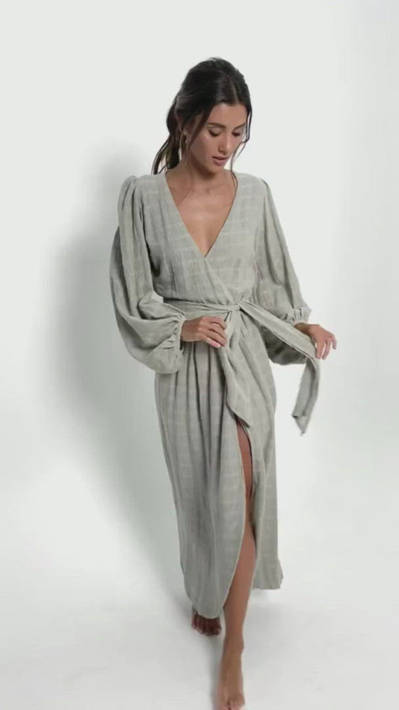 
            
                Load and play video in Gallery viewer, Short video of a young woman wearing a long gray open back cotton wrap dress. With puff sleeves and a V-neckline.
            
        