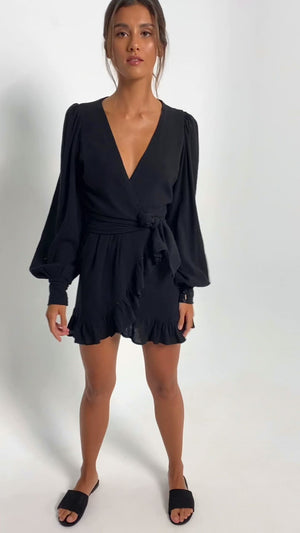 
            
                Load and play video in Gallery viewer, Short video of a young woman wearing a black cotton bare back mini dress. With puff sleeves and a V-neckline.
            
        