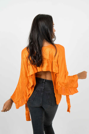 Orange backless shirt. With wide long sleeves. This shirt is in textured satin.