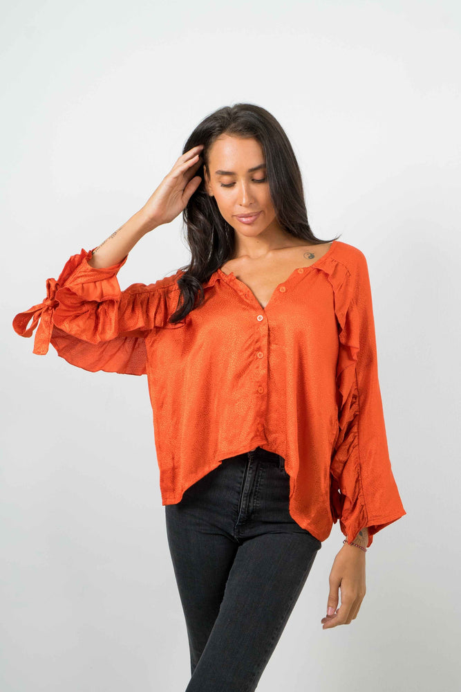 Backless tangerine shirt, with ruffled sleeves. Textured satin material.