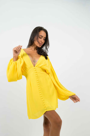 Backless yellow mini dress with long balloon sleeves. Zipper at the back.