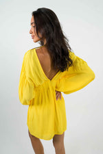 Yellow mini dress, with a bare V-shaped back. Long balloon sleeves. The size is marked with a wide elastic at the front. Zipper at the back.