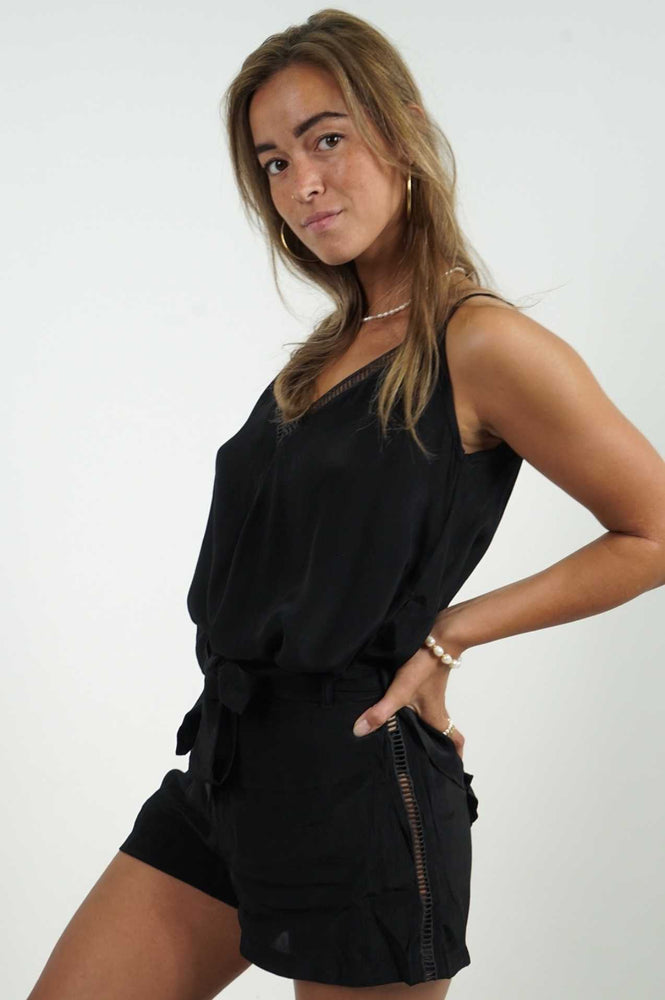 It's a mini black shorts, with details on each side. There is a belt at the waist. Fluid and light material.