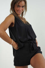 Ava black mini shorts, there are details on each side. It can be belted at the waist. Fluid and light material.