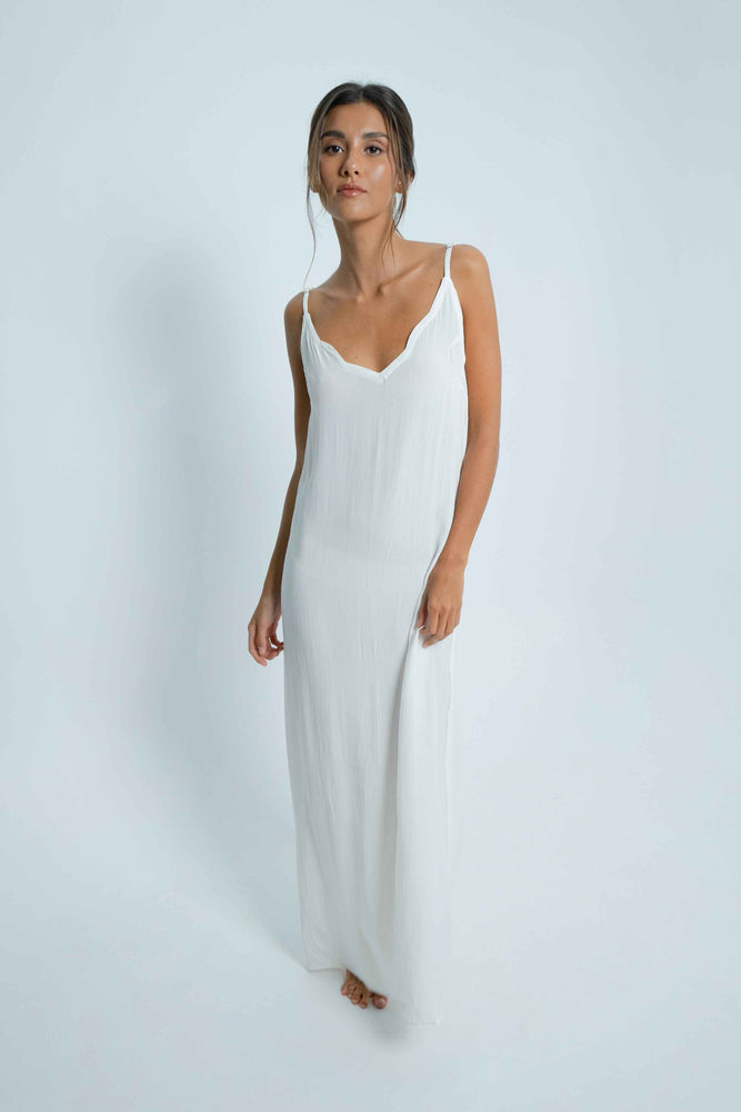 Long white dress with a V-shaped bare back, and a cloud detail on the border. Thin adjustable straps.