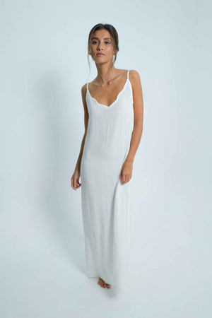 
            
                Load image into Gallery viewer, Long white dress with a V-shaped bare back, and a cloud detail on the border. Thin adjustable straps.
            
        