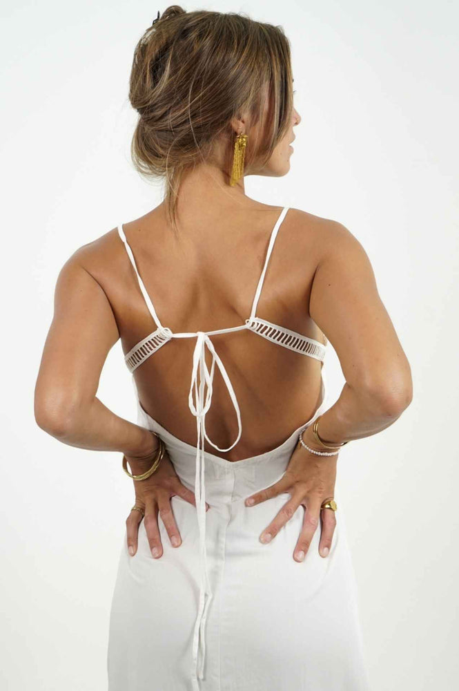 Beautiful bare back on a long white dress. It has adjustable straps to adjust the bare back and an opening on the left side. Back Cartel