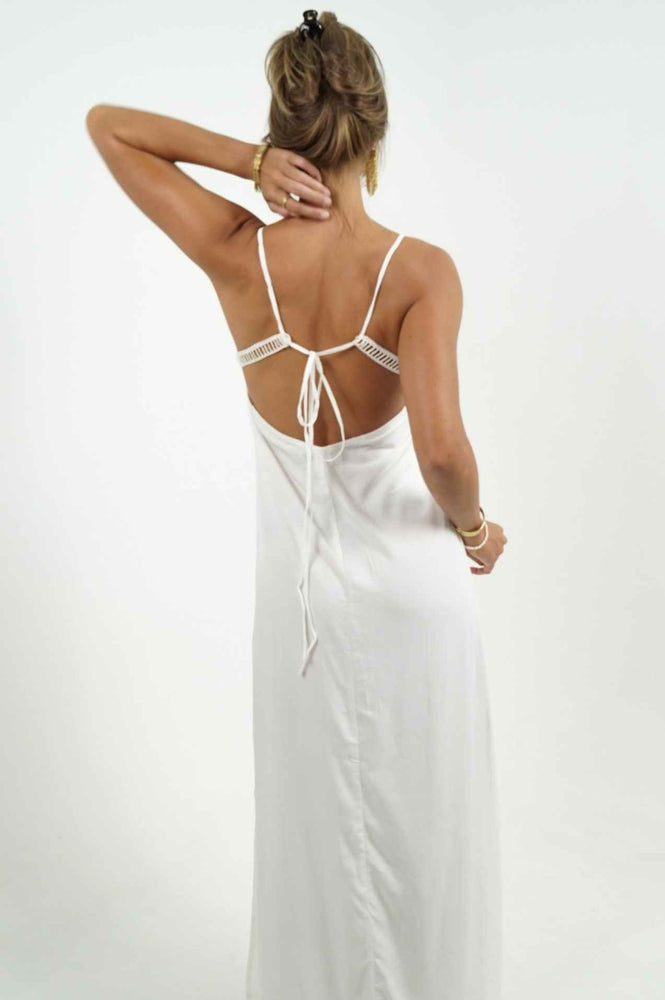 White long open back dress. Adjustable straps and an opening on the side. Pretty details on the neckline.