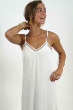 Lola white backless long dress. There are lace details on the neckline. The straps are adjustable in the back.