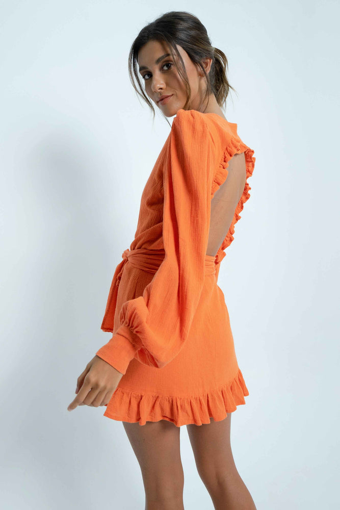 Backless orange mini dress. Puff sleeves. Closes like a crossover thanks to a wide belt that adapts to all body types. In coton.