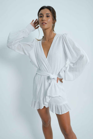 Backless white mini dress. Puff sleeves. Closes like a crossover thanks to a wide belt that adapts to all body types. In coton.
