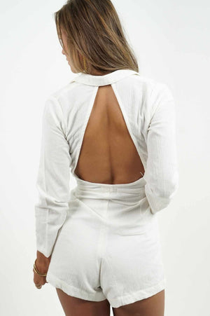 Beautiful bare back on a white linen jumpsuit. It has a blazer style neckline and a fitted belt at the waist.