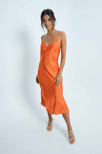 mid long dress in orange and satin fabrics. We love its discreet neckline and how it embraces the body.
