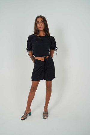 
            
                Load image into Gallery viewer, Black skirt by Back Cartel. Featuring a soft &amp;amp; comfy material with a twist front design and a mini length, team it with her matching JACK crop top and heels for a night out with the dolls.
            
        