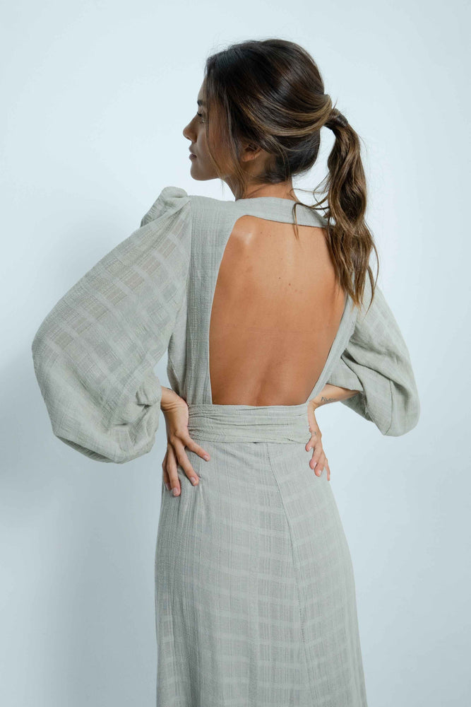 Beautiful square bare back on a long grey 100% cotton dress. It has puffy sleeves and closes like a cache-coeur with a wide belt.