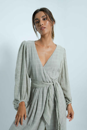 Long grey backless dress. Puff sleeves. Closes like a cache-coeur thanks to a wide belt that adapts to all body types.