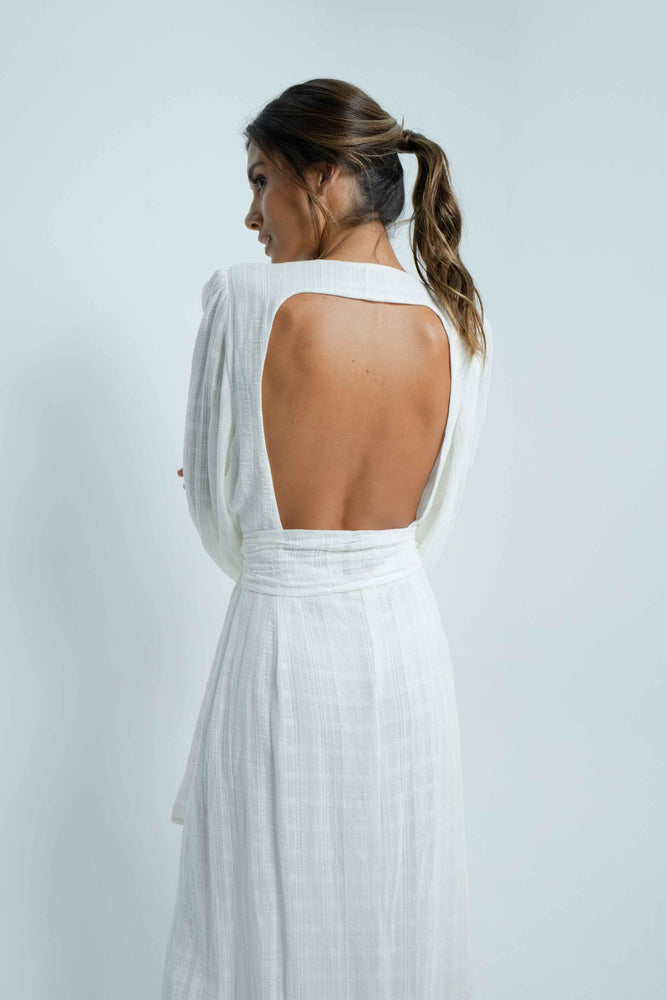 Beautiful square bare back on a long white 100% cotton dress. It has puffy sleeves and closes like a cache-coeur with a wide belt.